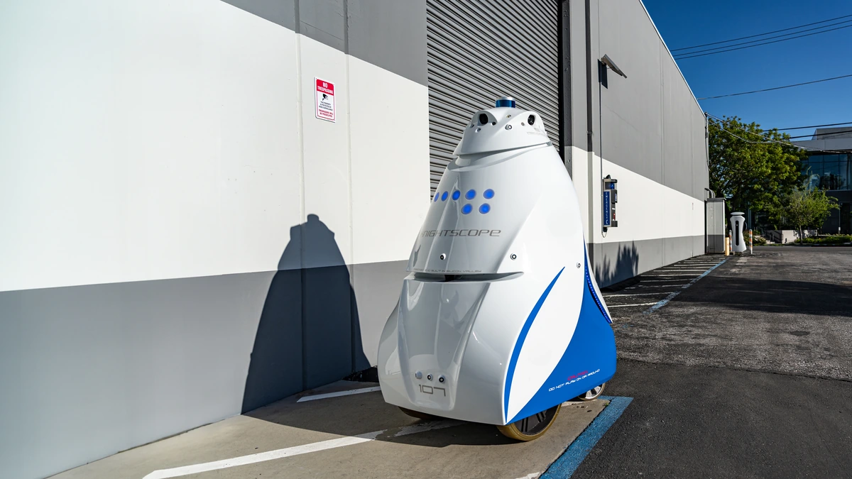 A fifth-generation Knightscope K5 security robot pictured in full beside a building in daylight.